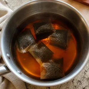 Black tea bags steeping in hot water.