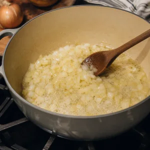 Cebolla picada salteándose en mantequilla derretida hasta quedar translúcida