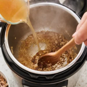 Chicken broth deglazing browned bits in the pressure cooker