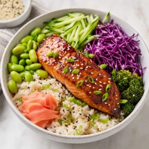 Teriyaki-Lachsbowl mit Sesamreis Gurke Rotkohl Edamame und eingelegtem Ingwer