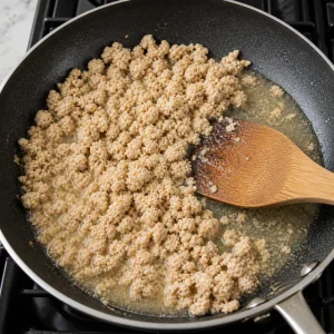 Cooked chicken moistened with broth in a skillet