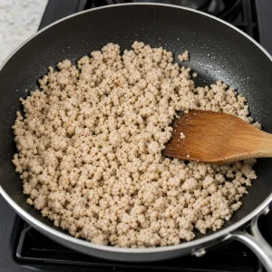 Ground chicken cooking in a skillet