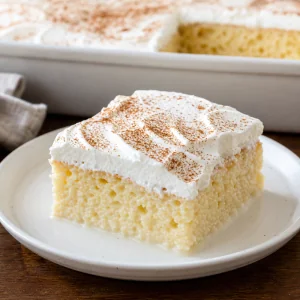 Stück Tres-Leches-Milchkuchen mit Schlagsahne und Zimt