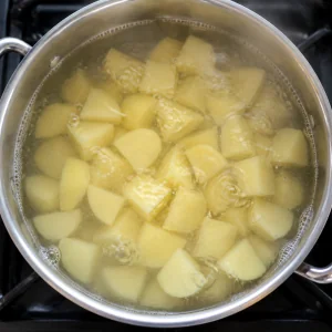 Pezzi di patata che bollono in casseruola per il ripieno dei varenyky.