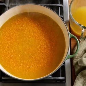 Lentilles corail et bouillon de legumes mijotant en soupe dal doree