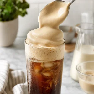 Espuma de miel batida colocada generosamente sobre cafe helado