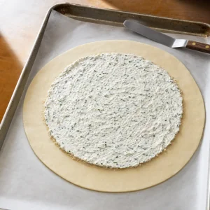 Goat cheese filling spread over pastry with a wide bare border