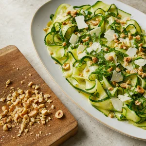 Hazelnuts, basil, and shaved pecorino scattered over zucchini ribbons